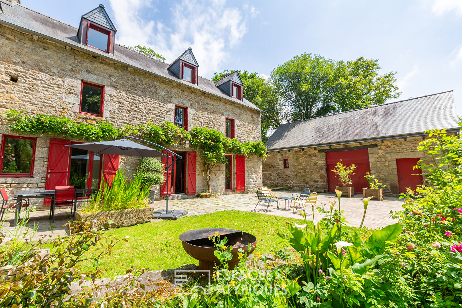 Old renovated mill with outbuildings in a green setting