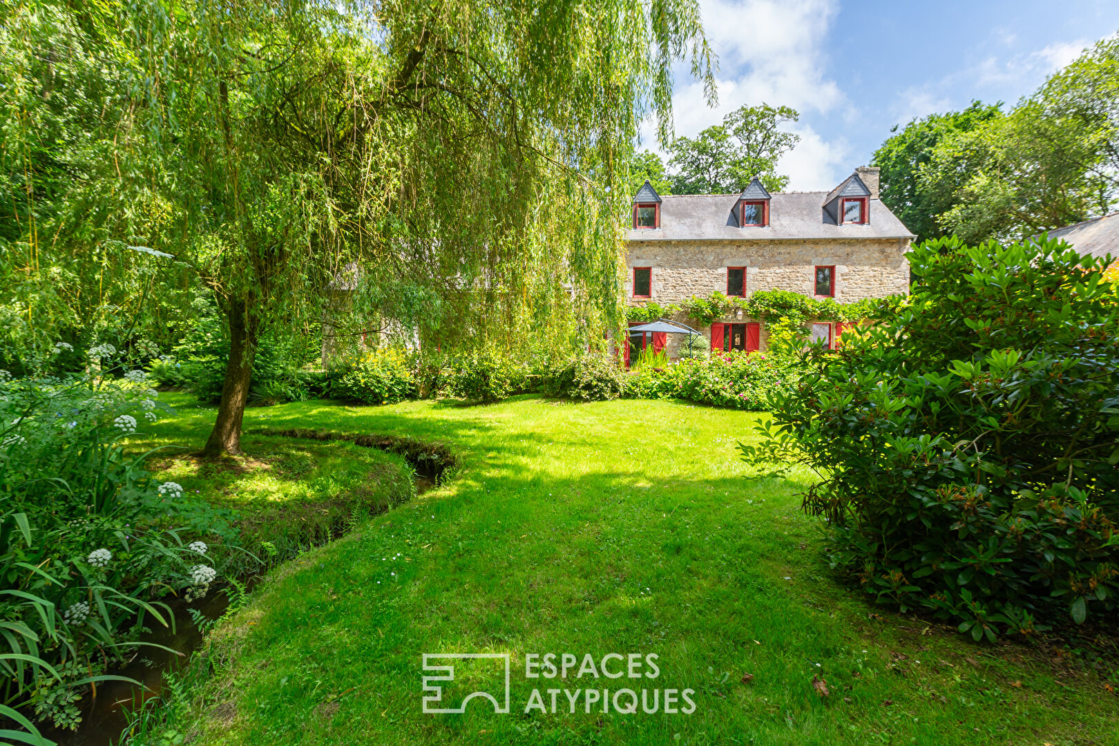 Old renovated mill with outbuildings in a green setting