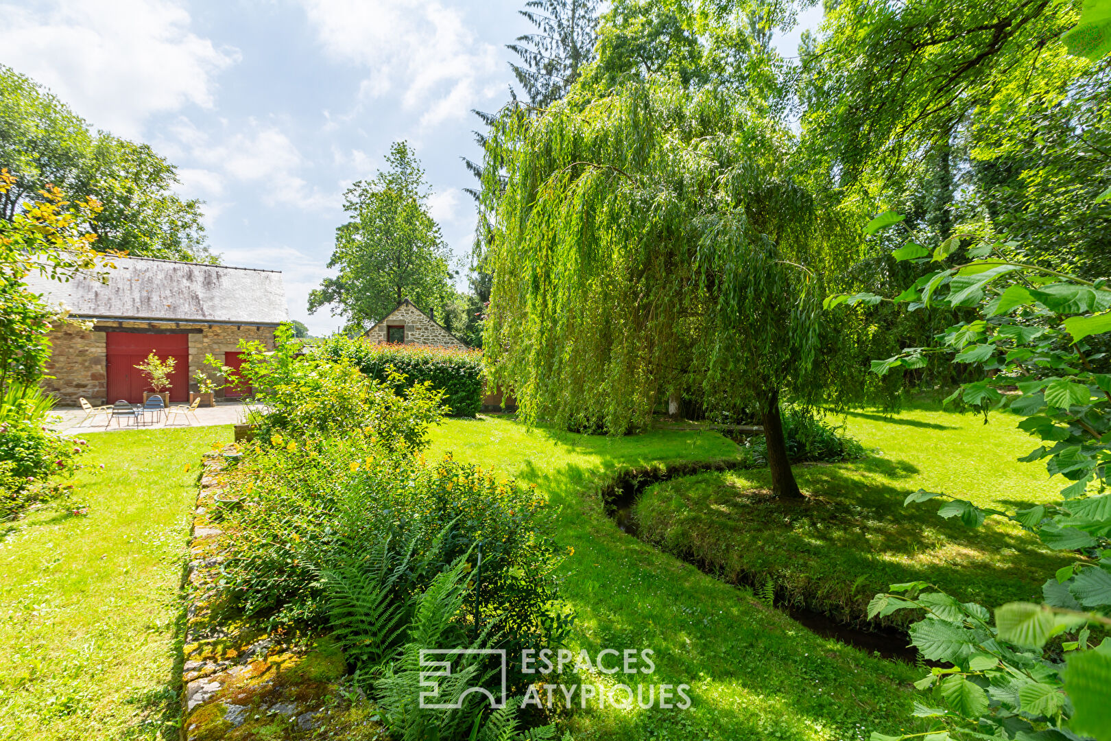 Old renovated mill with outbuildings in a green setting