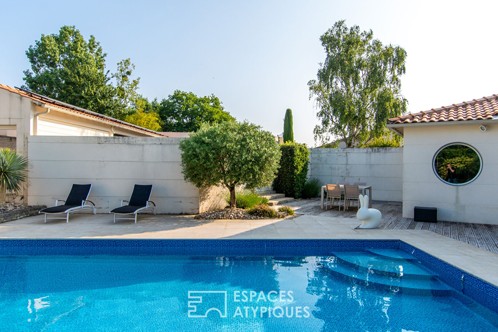Single-story architect-designed house with swimming pool and outbuildings