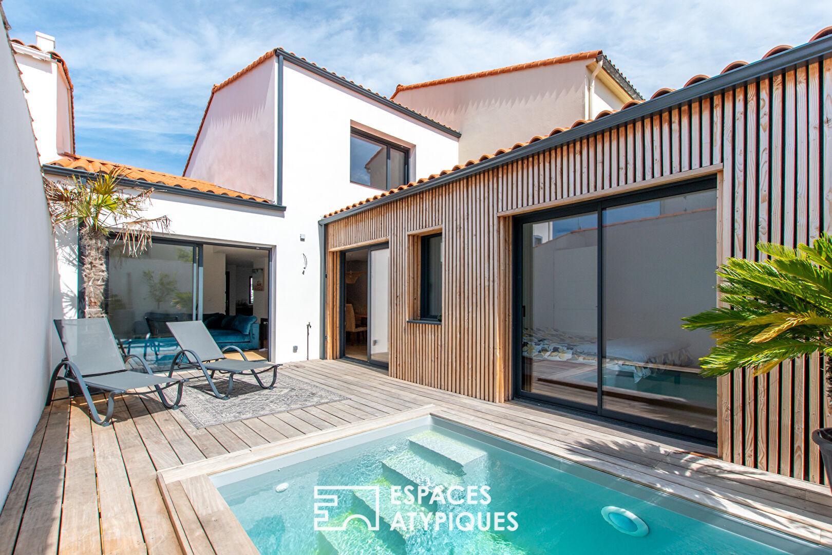 Maison rénovée avec piscine dans un patio ensoleillé