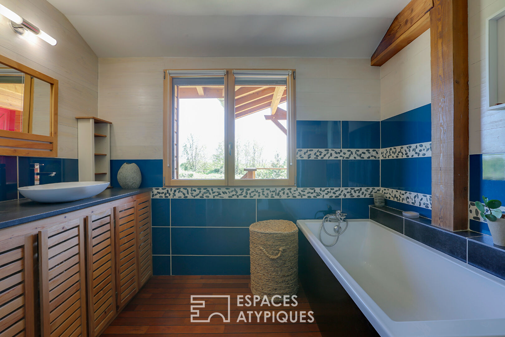 L’élégante maison en bois dans son écrin de verdure