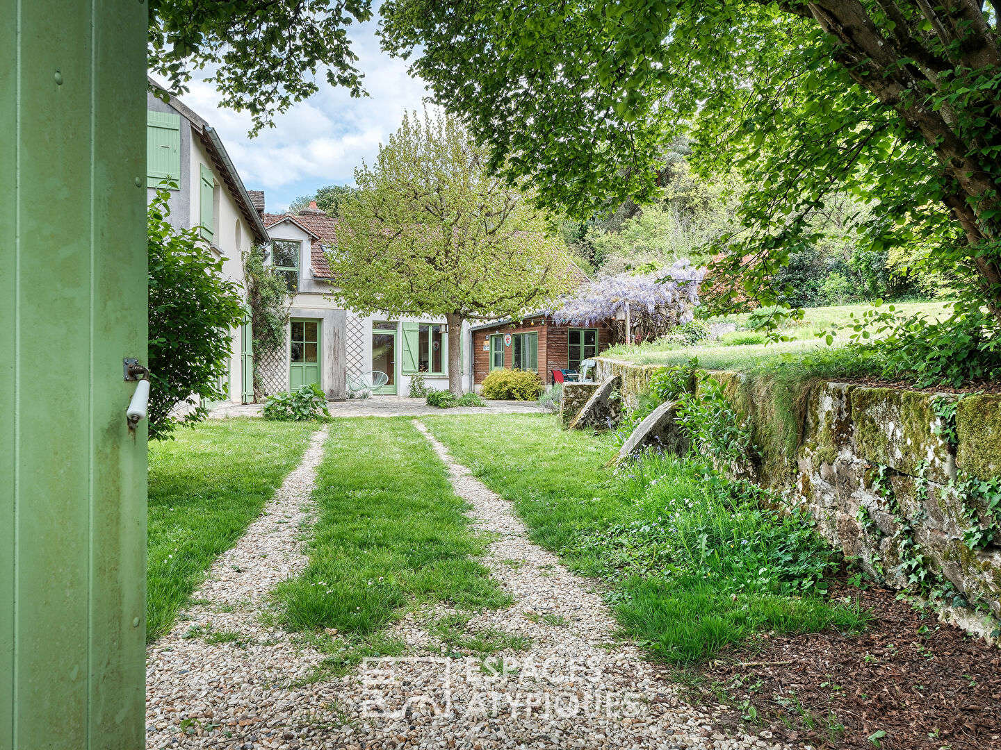 La Maison en pierre dans son écrin de verdure