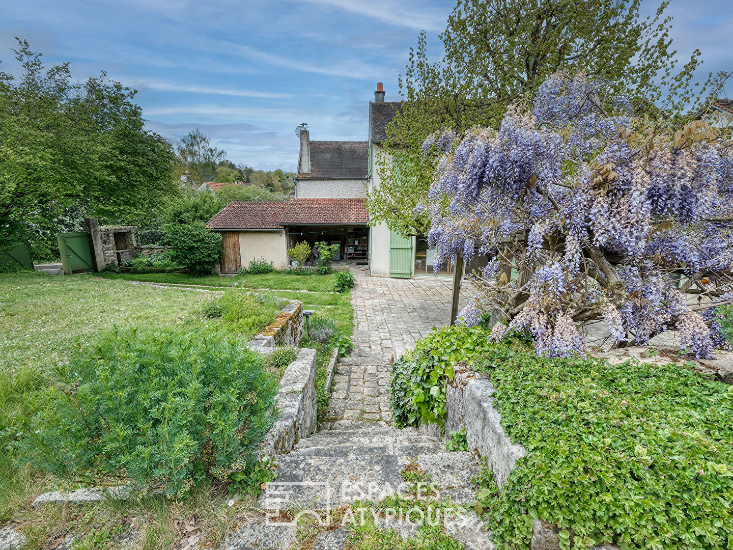 La Maison en pierre dans son écrin de verdure