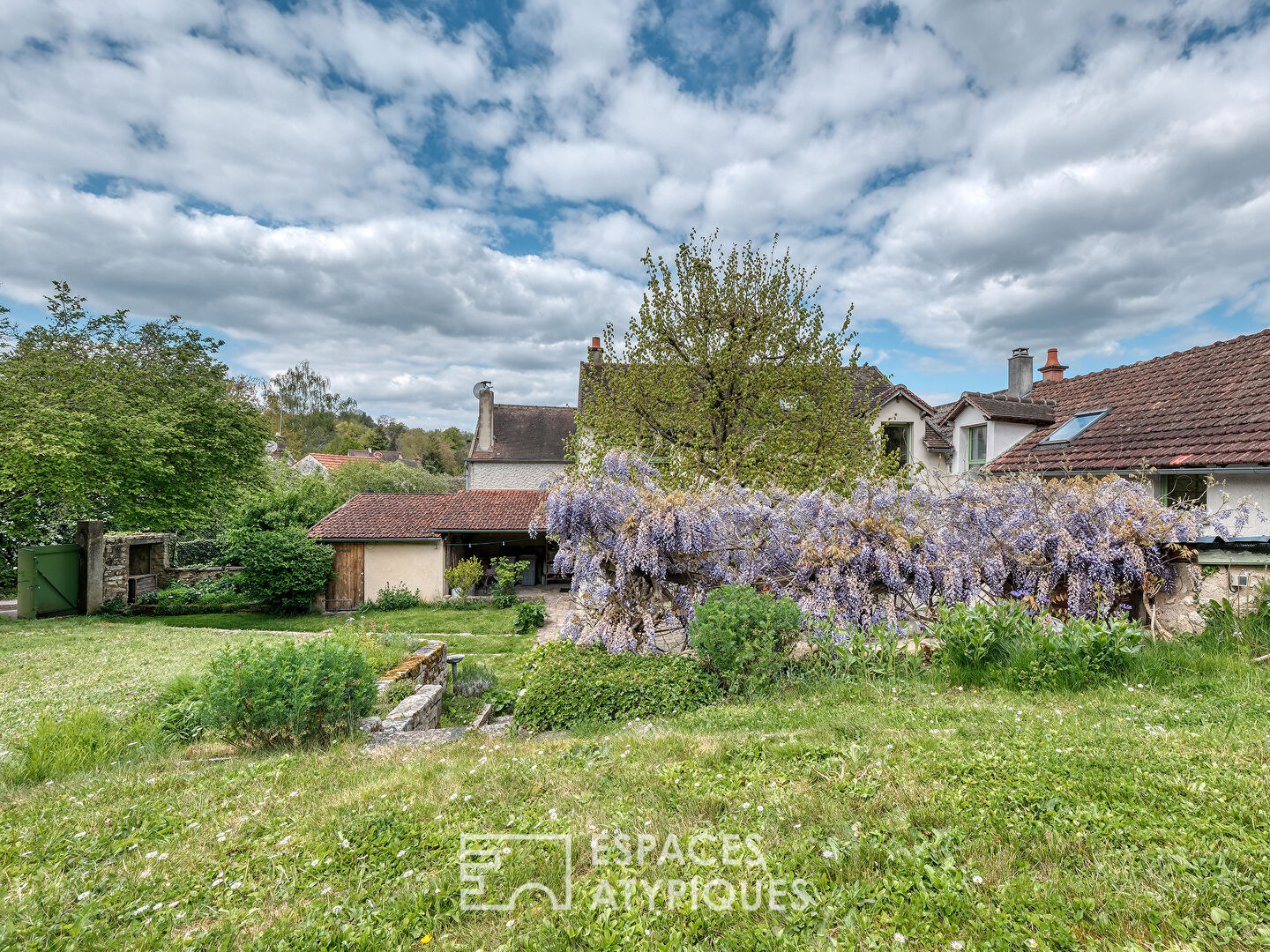 La Maison en pierre dans son écrin de verdure