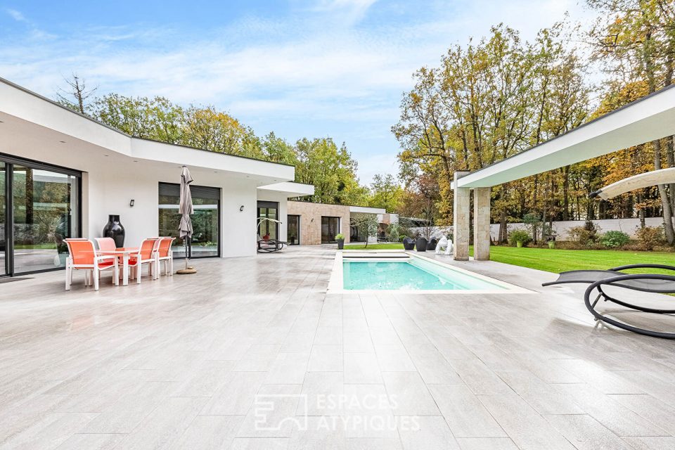 Villa contemporaine dans un environnement boisé.