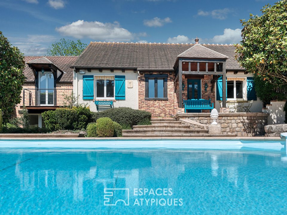 Maison familiale avec jardin paysager, piscine et dépendance.