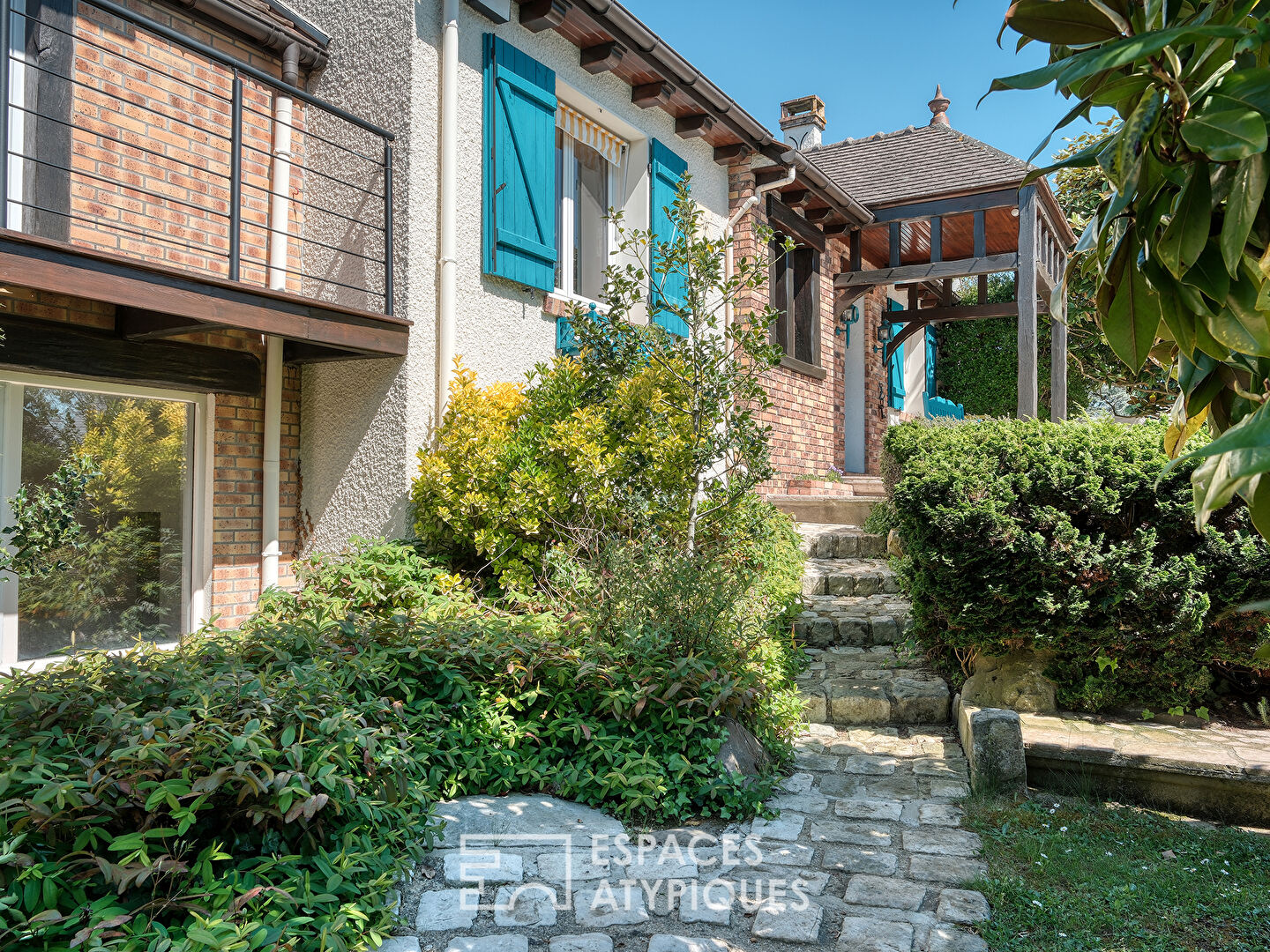 Maison familiale avec jardin paysager, piscine et dépendance.