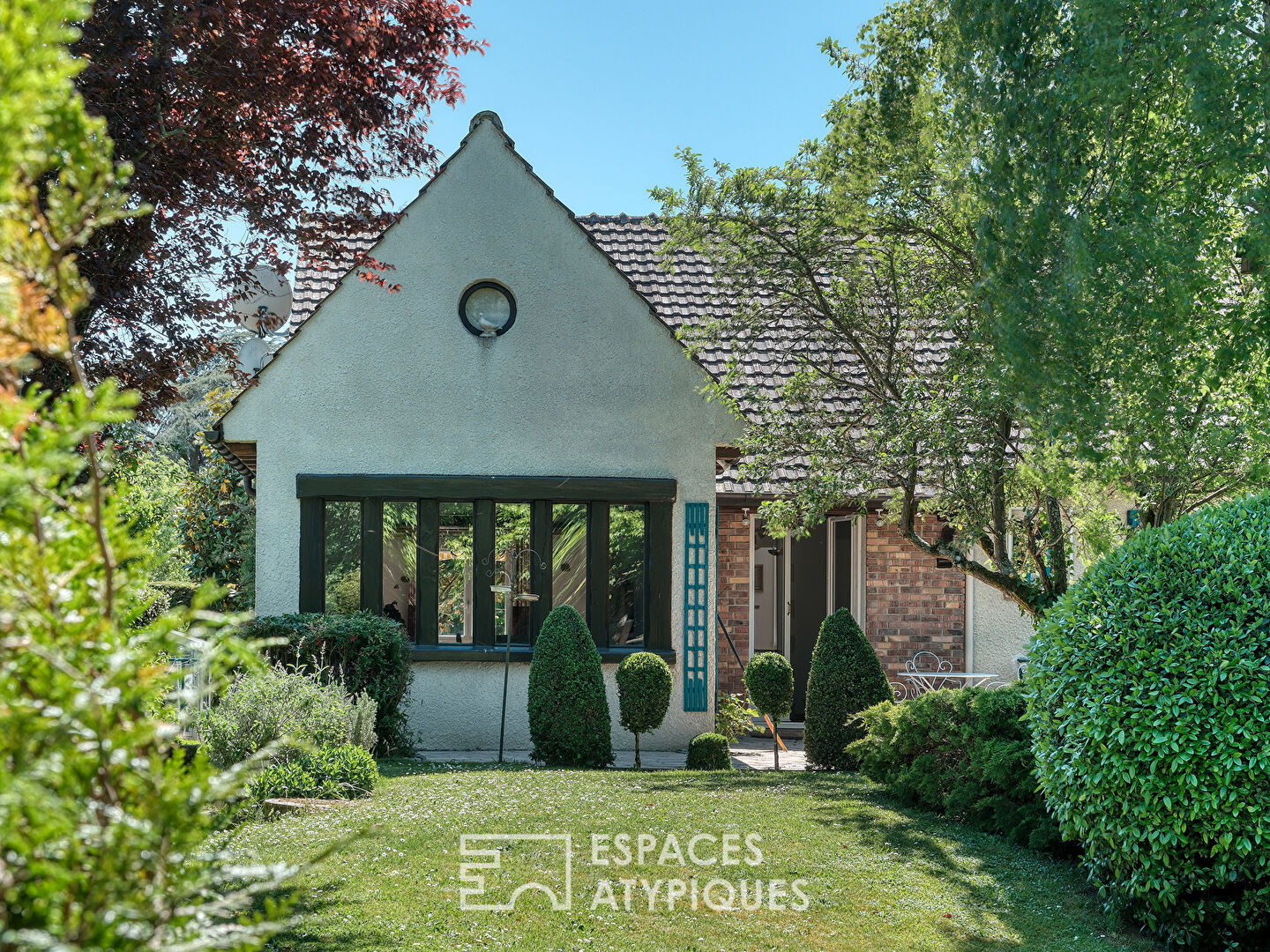 Maison familiale avec jardin paysager, piscine et dépendance.