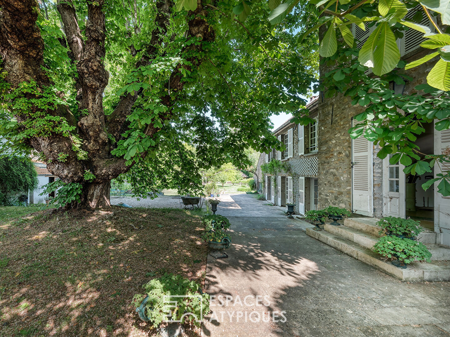Maison de maître en pierre avec piscine au coeur d’un parc arboré