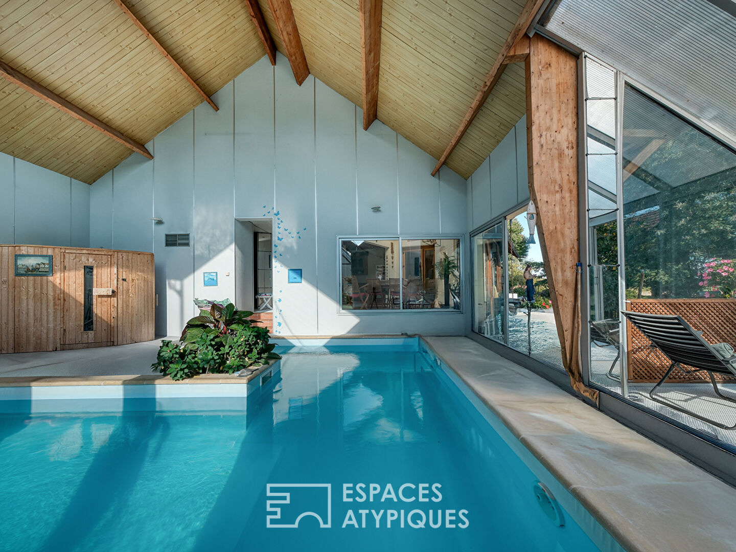 Maison familiale avec jardin arboré et piscine intérieure.