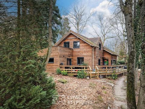 Maison familiale en bois au coeur d&rsquo;un environnement boisé.
