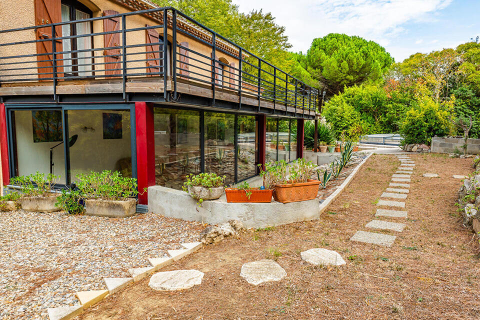 Maison années 80 avec véranda, double garage, jardin et piscine.