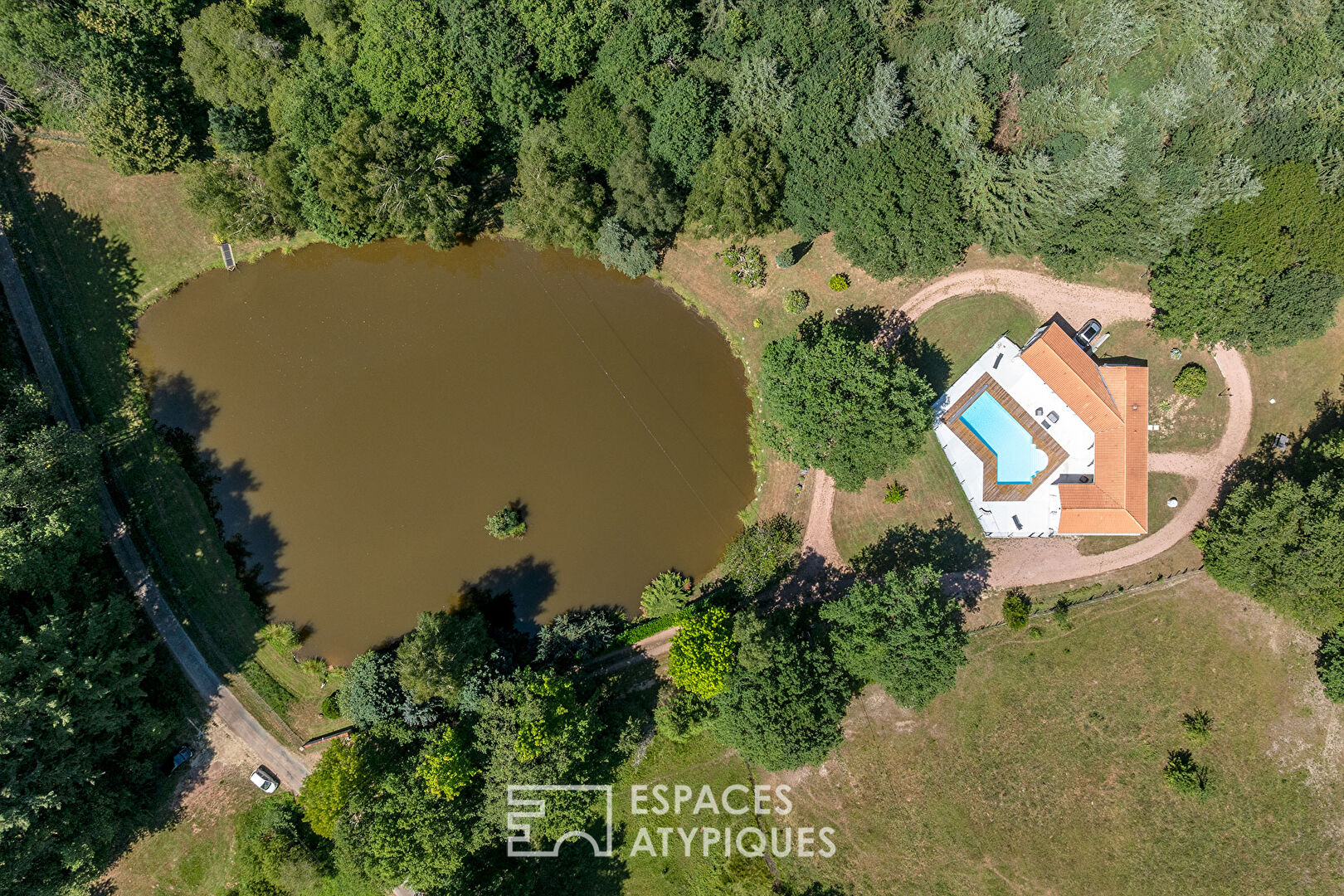 A single-story life, its swimming pool and its pond at the edge of the forest
