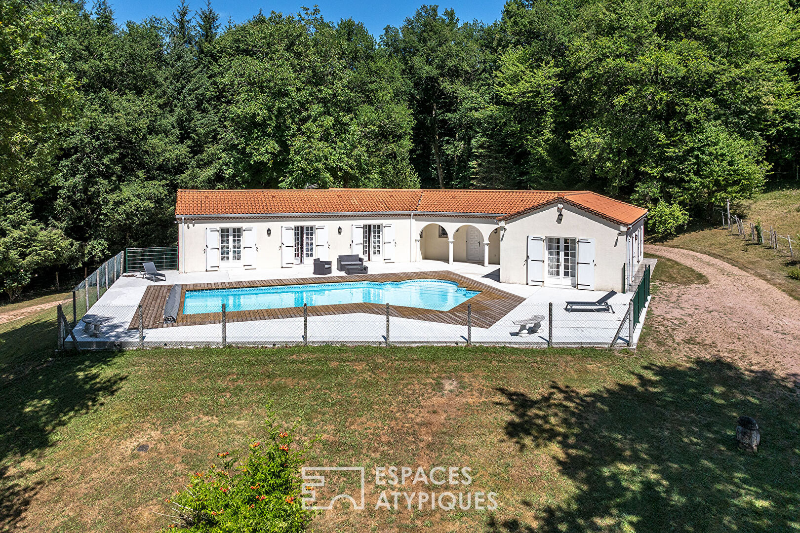A single-story life, its swimming pool and its pond at the edge of the forest