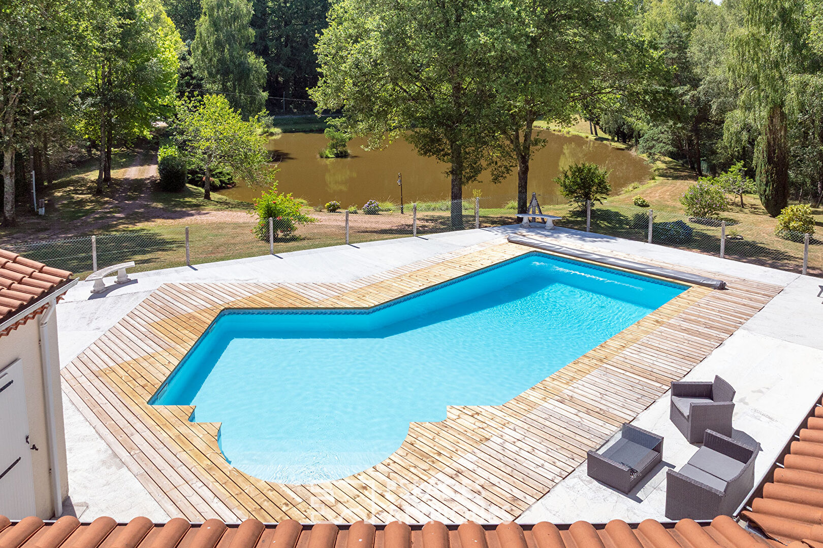 A single-story life, its swimming pool and its pond at the edge of the forest