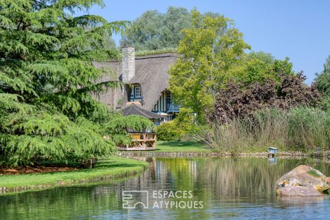 Noble thatched cottage and its park crossed by the Bec