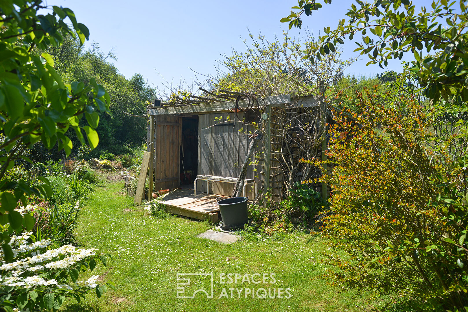 Maison d’artistes baignée de la lumière de son jardin paysagé