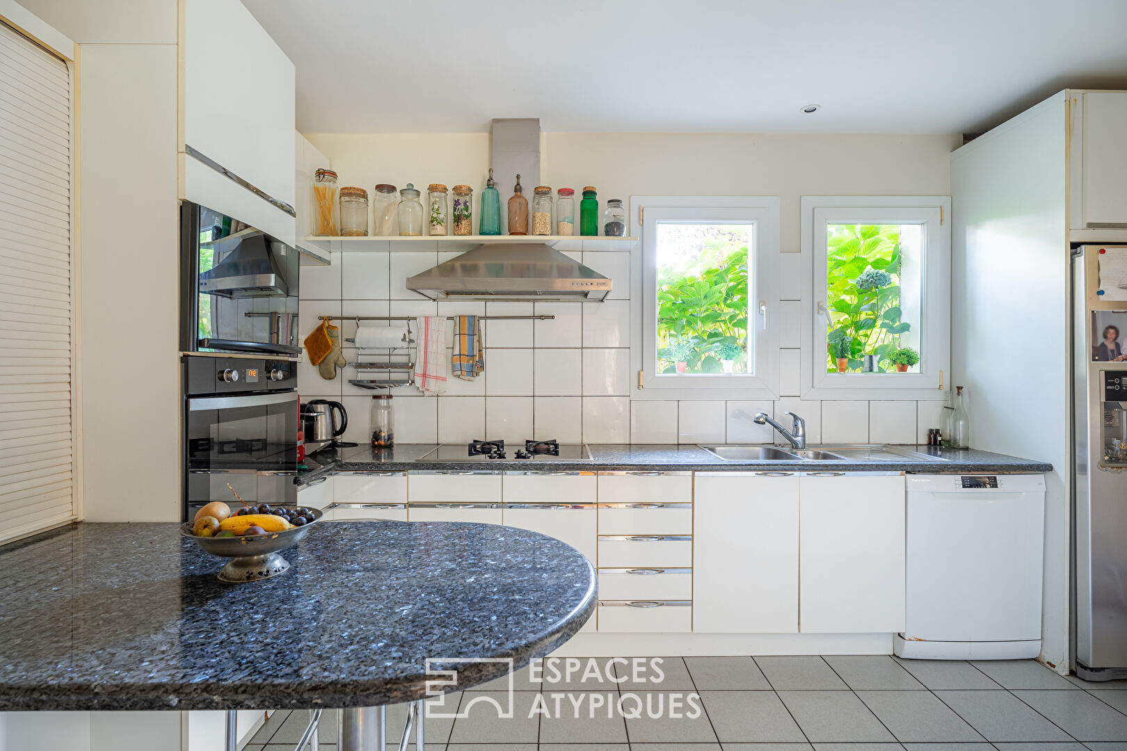 Maison d’Architecte avec jardin paysager dans un environnement boisé.