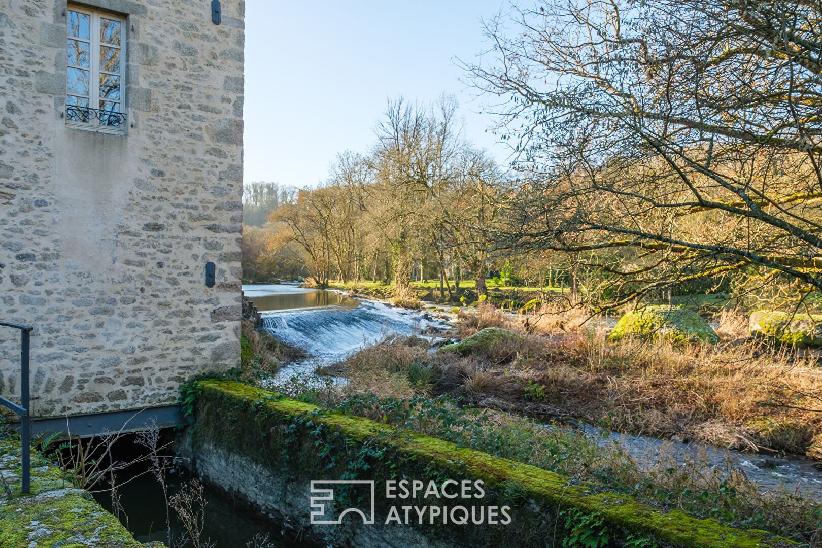 Moulin au bord de l&rsquo;eau avec piscine à proximité d&rsquo;un village