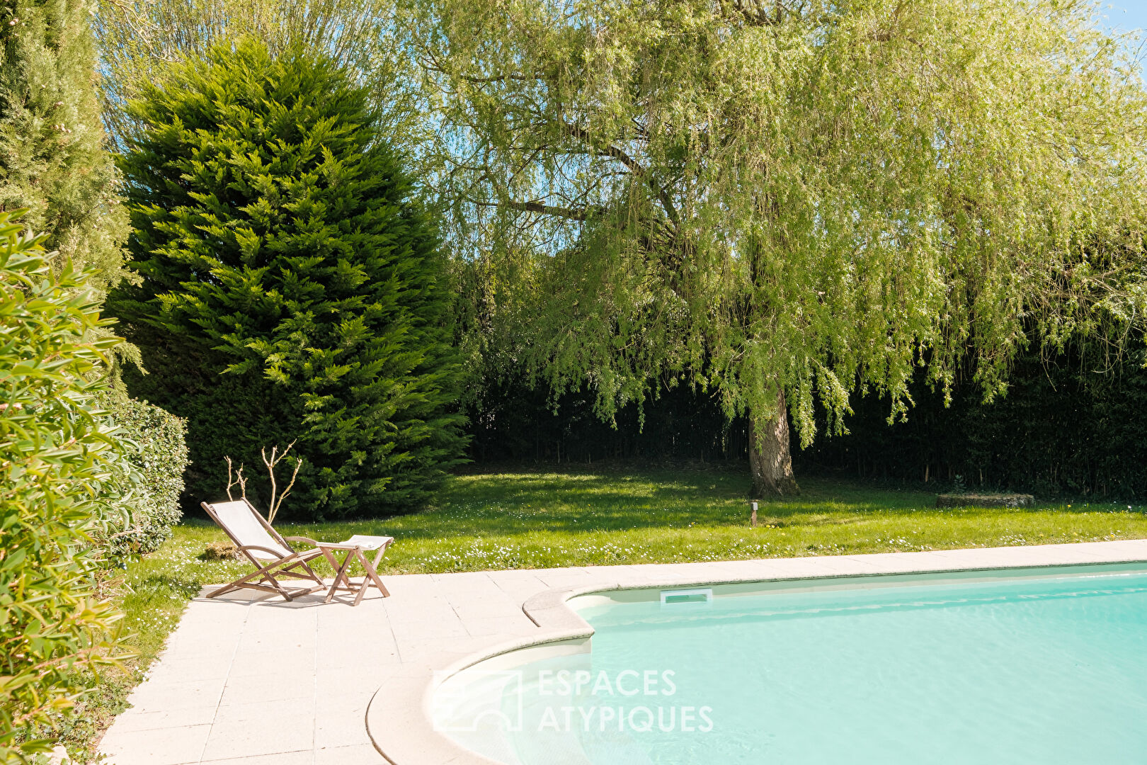 Former 15th century mill reinvented with swimming pool at the foot of a castle
