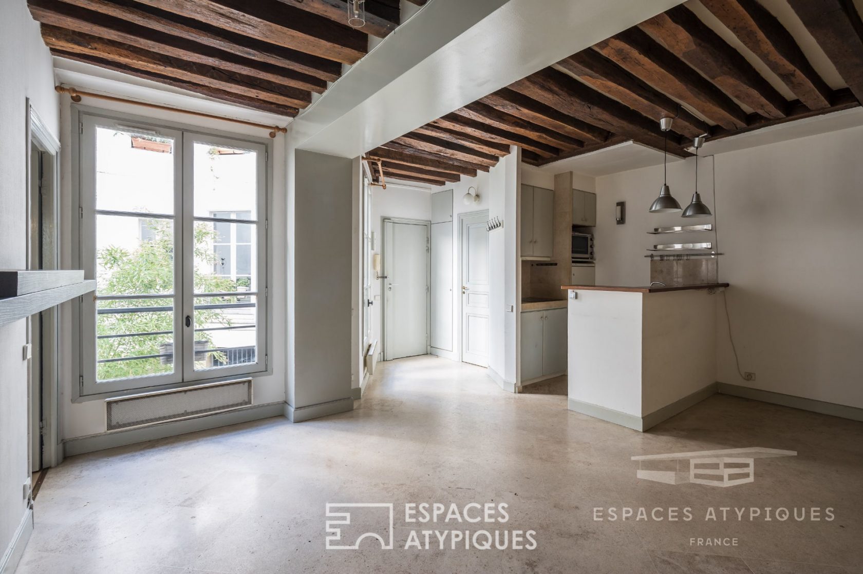 Appartement avec pierres et poutres apparentes dans le Marais