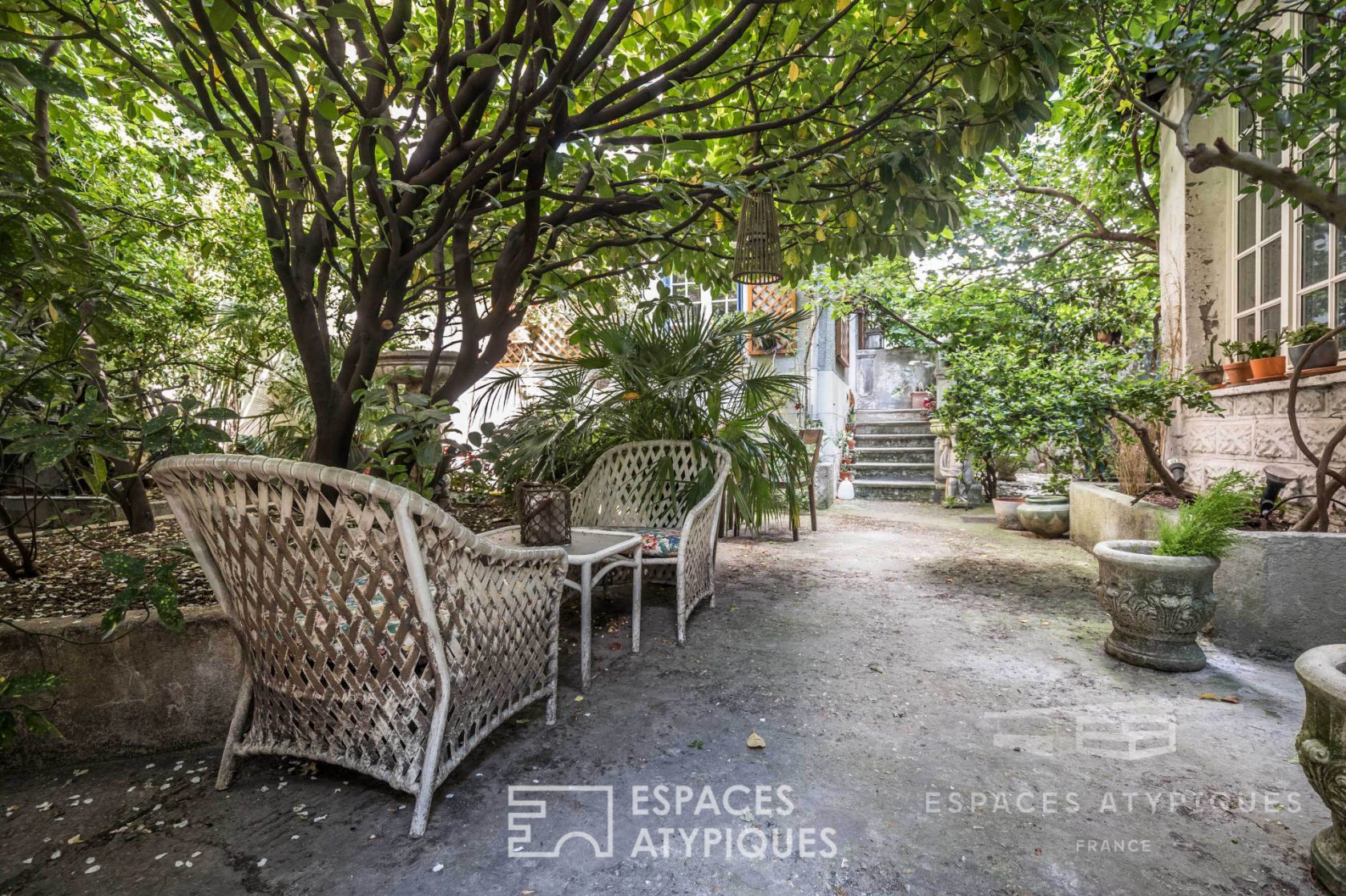 Maison de pucier autour d’une cour arborée